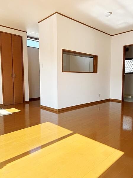 リビング全体に明るい日差しが広がる設計です。木目調の床材が温かみを演出しています。室内はシンプルな仕上がりですっきりとした空間です。出入り口や窓が複数あり風通しも期待できます。