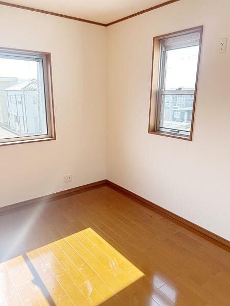 二面に窓があり明るい光が差し込む洋室です。ナチュラルなフローリングが心地よい雰囲気を演出します。コンパクトなサイズで使いやすい空間です。壁にはコンセントも配置されています。採光性の高さが特徴です。