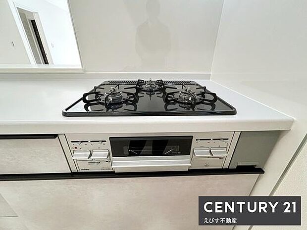 三口コンロが備わったキッチンです。調理スペースも広々としていて清潔感があります。グリルも設置されており日々の料理がしやすい仕様です。シンプルなデザインでお手入れも簡単です。