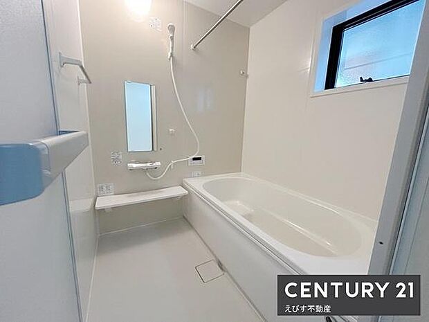 明るい色調のバスルームで窓付きのため換気がしやすい空間です。洗い場にはベンチがあり使い勝手が良い設計です。壁面には手すりがあり浴槽も広めのつくりとなっています。清潔感のある仕様です。