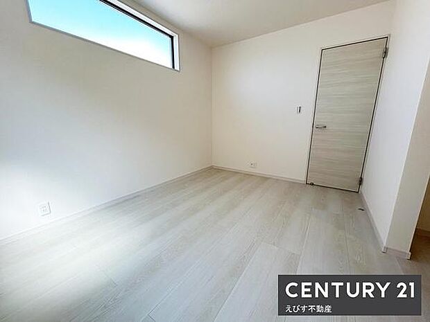 明るい光が差し込む洋室です。シンプルな内装なので家具の配置や使い方に幅が広がります。落ち着いたトーンの床材がお部屋全体をすっきりと演出しています。木目調のドアが空間のアクセントになっています。