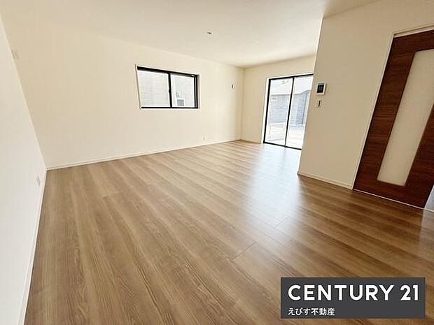 広々としたリビングは開放感ある空間が広がっています。大きな窓から自然光が入り室内が明るく感じられます。フローリングの質感も清潔感を演出しています。