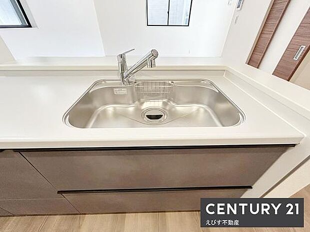 シンプルなデザインのキッチンシンクが印象的です。作業スペースもゆったり確保されています。水回りの使い勝手を考慮した設計です。収納スペースも十分に確保されています。清潔感のある雰囲気です。