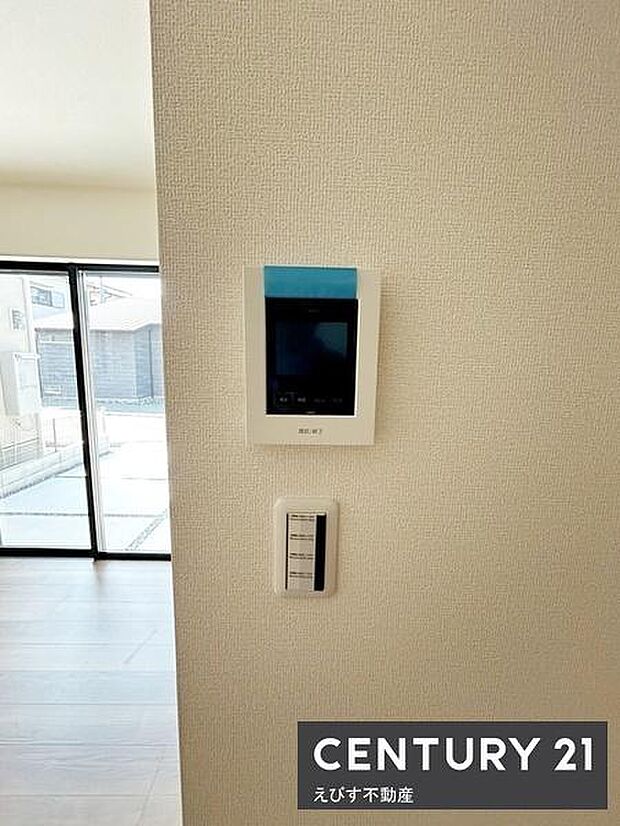 シンプルなデザインの室内インターホンが設置されています。壁面もすっきりしていてお手入れもしやすい印象です。隣にはスイッチパネルもあり操作性に配慮されています。周囲のスペースも広く取られています。