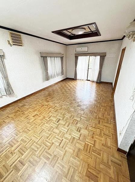 【一部AIモノ消し済み・実際の室内状況優先】大きな窓から日差しがたっぷり入る明るいリビングです。床は木目調で落ち着いた雰囲気が広がります。