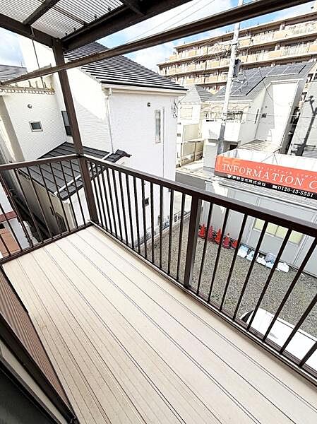 広々としたバルコニーは日差しが差し込み開放感があります。屋根付きなので天候を気にせず使えます。手すりは安全性を考慮したデザインです。周囲の景色を楽しめる位置にあります。