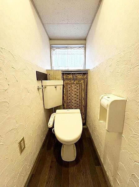 ナチュラルな色合いの床と壁が落ち着いたトイレ空間を演出しています。窓から光が入り明るい印象です。