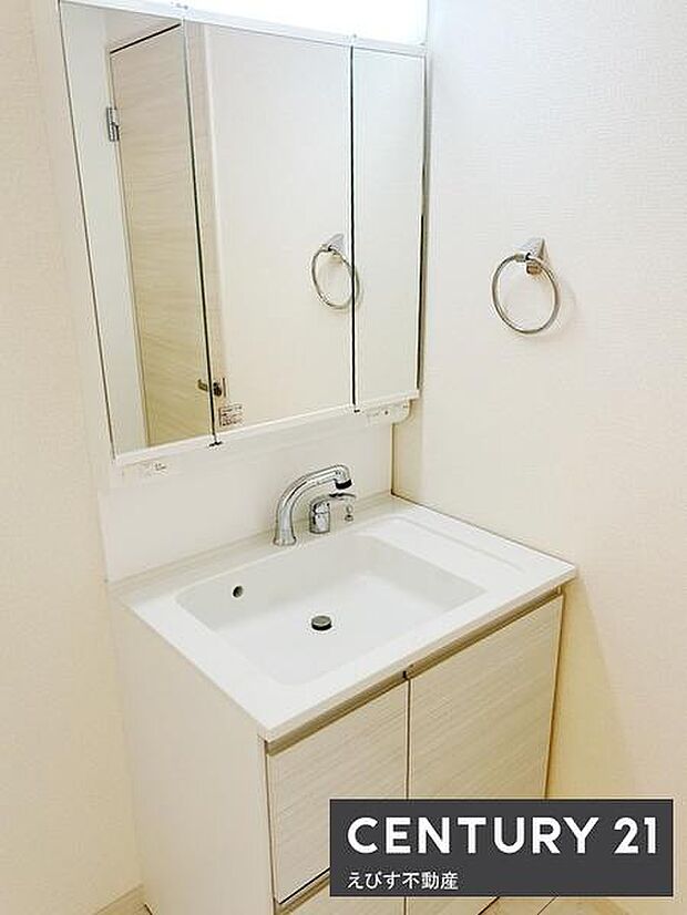 暮らしを快適に変えるシャワー付洗面台。三面鏡がついており収納スペースも充実しています。洗面ボウルは広めで使いやすい設計です。壁の色合いが空間を明るく見せてくれます。