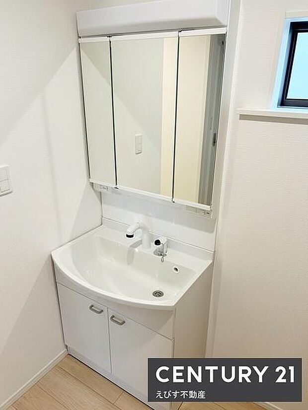 白を基調とした洗面台が清潔感を演出しています。収納スペースも確保されており使い勝手に配慮されています。大きめの鏡が設置されており毎日の身支度にも便利です。窓があり明るい空間が保たれています。