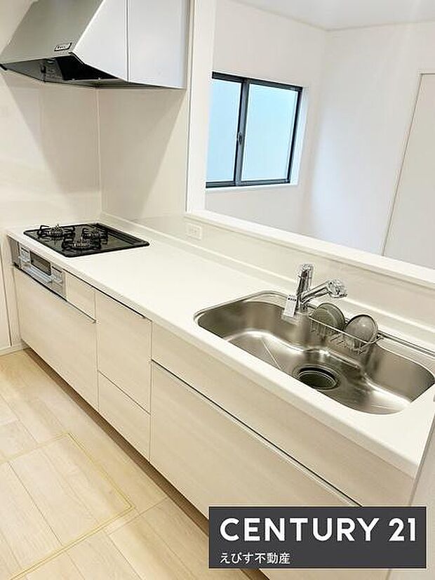 明るい色調のキッチンが空間をすっきりと感じさせます。作業スペースが広く調理もはかどります。シンクやコンロが使いやすく配置されています。窓からの採光がキッチン全体を明るくしています。