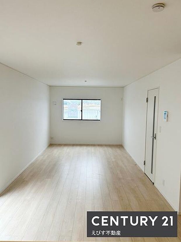 広々とした空間が広がるリビングです。窓から自然光が差し込み室内が明るく感じられます。シンプルな内装で使いやすい間取りとなっています。床材が落ち着いた色味で清潔感があります。