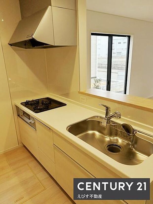 キッチンはシンプルで落ち着いたデザインとなっています。明るいカラーの床とカウンターが全体に一体感を与えています。広めのシンクやコンロを備えており作業スペースも確保されています。