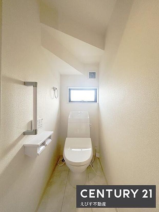 明るい光が差し込む窓付きのトイレです。トイレは快適な温水洗浄便座付 。シンプルで無駄のないデザインが特徴です。