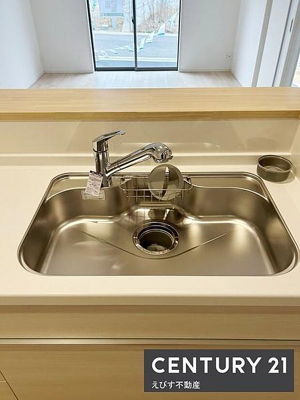 シンプルなデザインでお手入れもしやすいキッチンです。広々としたシンクは洗い物に便利です。清潔感のあるステンレス素材を採用しています。カウンター越しに開放感も感じられます。