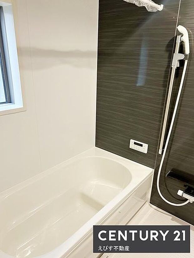 清潔感のあるバスルームです。モノトーンの配色が印象的でスタイリッシュな雰囲気が特徴です。窓付きで自然光が差し込みます。収納棚や手すりも設置されており機能性も兼ね備えています。