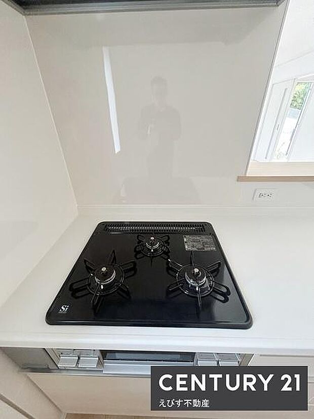 三口コンロが使いやすく配置されており調理の幅が広がります。キッチンカウンターは広めで作業がしやすい設計です。清潔感のあるシンプルなデザインが印象的です。