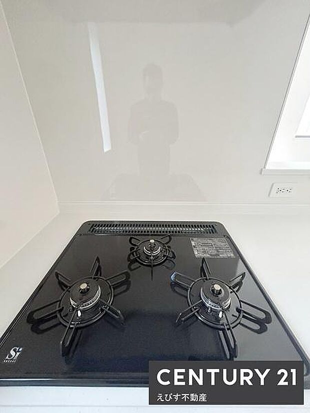 シンプルなデザインのガスコンロを採用しています。お手入れしやすいフラットな天板です。料理の幅が広がる3口タイプで効率的に調理できます。キッチン全体が明るい印象です。