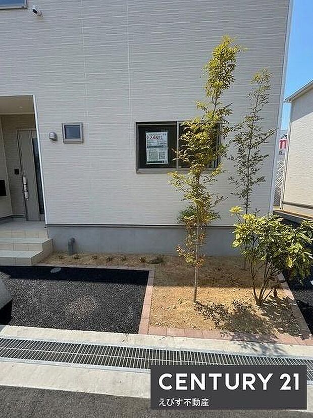 シンプルな外観に植栽が調和し清潔感があります。玄関先のスペースがすっきりと整えられています。道路との境界もきちんと区分けされています。アプローチ部分が見やすい配置です。