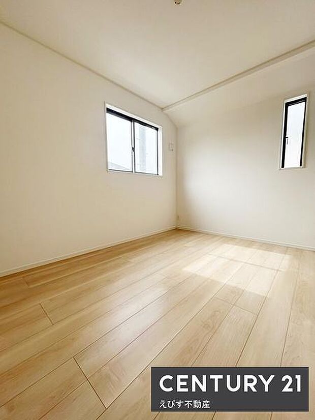 2つの窓から自然光がしっかり入る明るい洋室です。白を基調とした内装が空間を開放的に演出します。床の木目が落ち着いた雰囲気を感じさせます。シンプルな設計でレイアウトも自由に楽しめます。