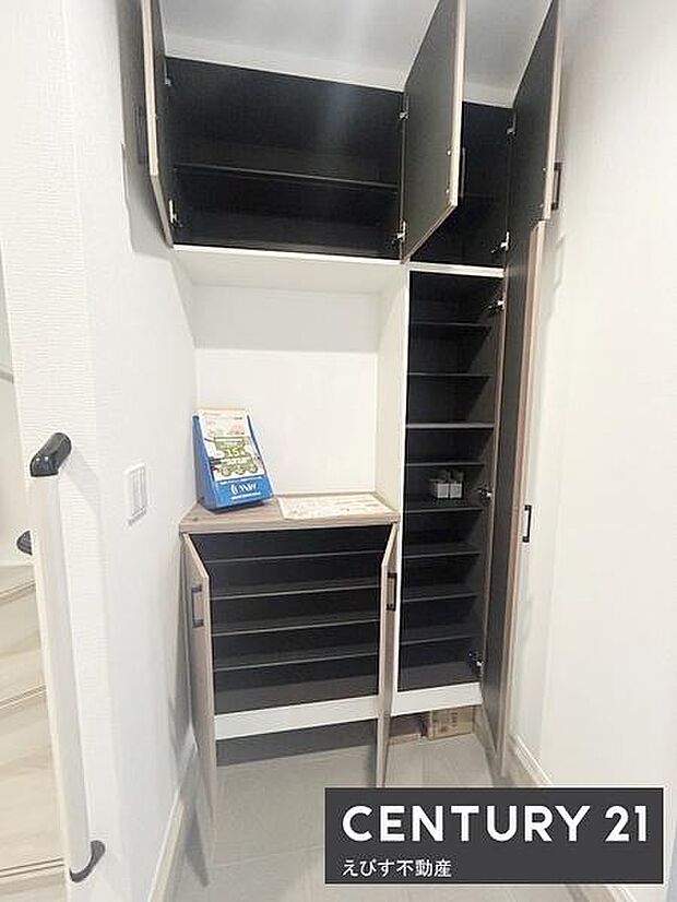 玄関収納が充実しており上部と下部に複数の扉付き収納スペースがあります。スッキリとしたデザインで整理整頓がしやすそうです。玄関横には手すりが設置されており安心して使えます。全体的に明るい印象の玄関です。