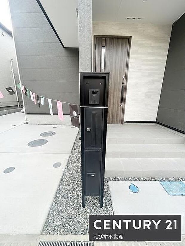 スタイリッシュなデザインの宅配ボックスが設置されています。玄関前まで舗装されたアプローチが続いております。外壁の色合いがシンプルで落ち着いた雰囲気を演出しています。