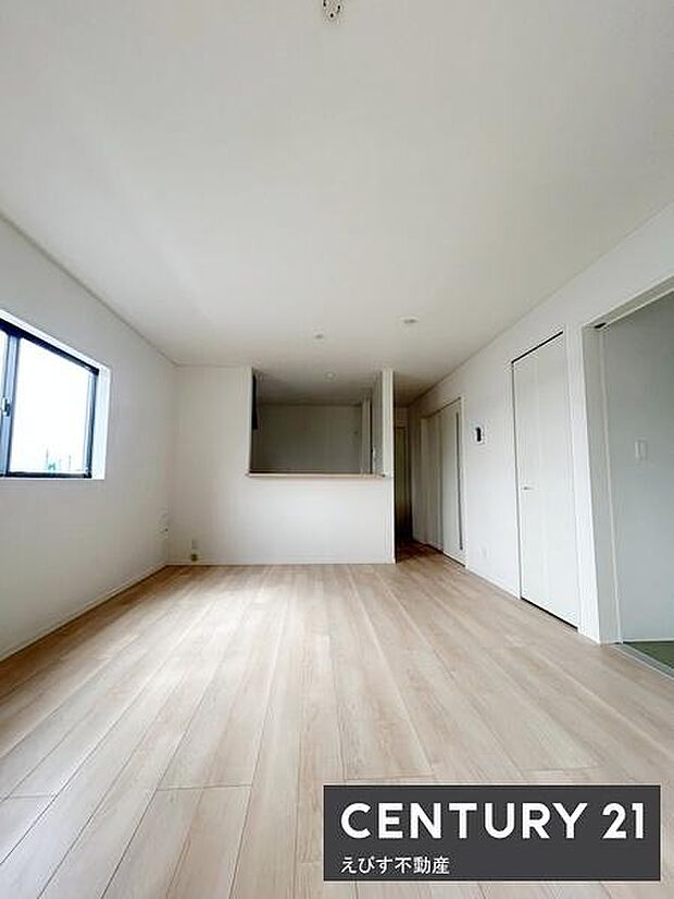 明るいリビングが広がり白を基調とした落ち着いた空間です。床材の色合いが全体を爽やかに演出しています。窓からの自然光で開放感が感じられます。カウンター型のキッチンもポイントです。