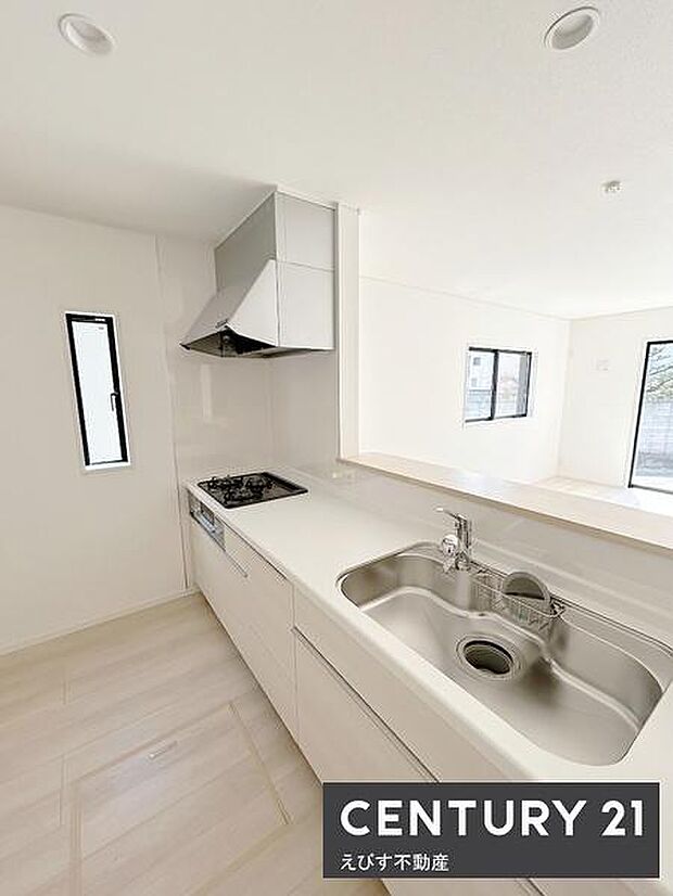 明るく開放感のあるキッチンです。カウンター付きで作業がしやすいレイアウトです。シンクとコンロが配置され清潔感のある空間にまとまっています。床や壁の色合いも統一され洗練された印象です。