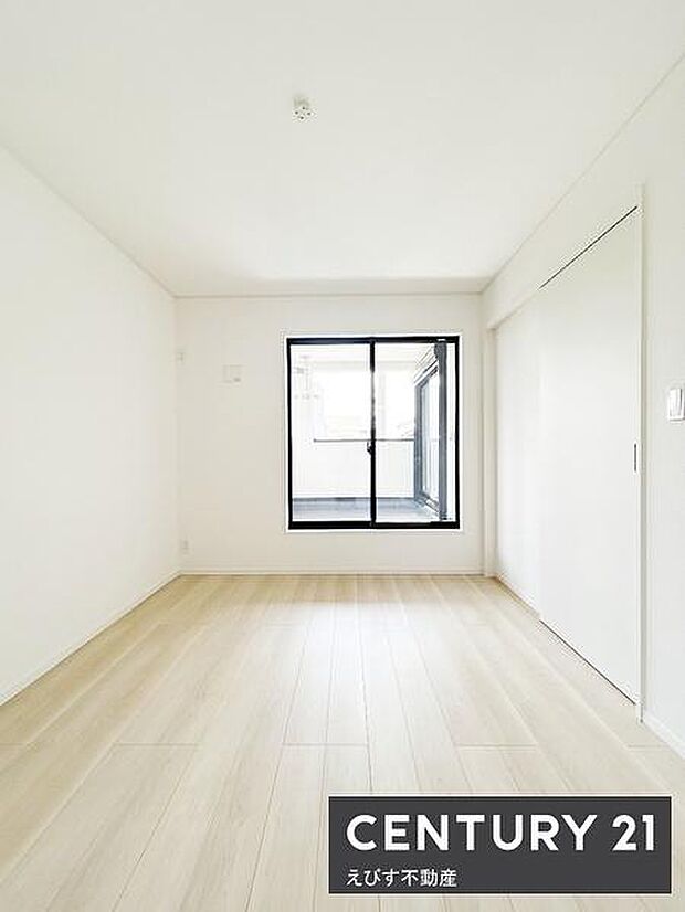 白を基調とした洋室で明るく開放感があります。窓からの自然光が室内を心地よく照らします。シンプルな内装で幅広いインテリアに対応できます。収納スペースも確保されています。