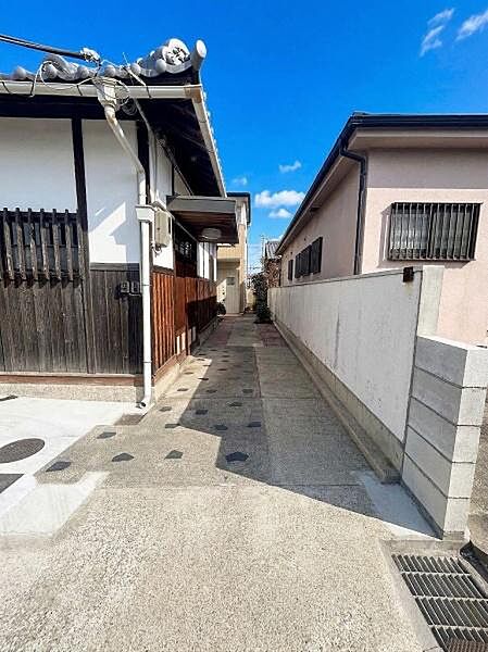 縦列で駐車2台可能（車種による）。玄関アプローチが広くスムーズな動線が確保されています。晴れた日には青空が映え周囲の静かな環境が感じられます。外壁のメンテナンスも丁寧に行われています。