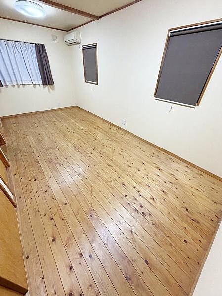 【一部AIによるモノ消し済み】洋室は木目調のフローリングが広がりシンプルで使い勝手の良い空間です。窓が複数あり採光も期待できます。壁や天井も明るい色合いですっきりとした印象です。