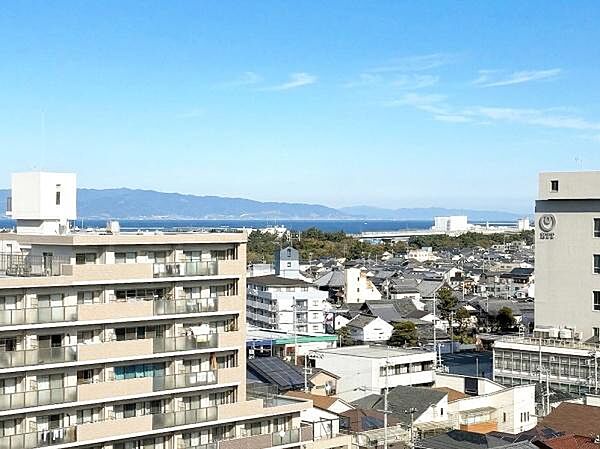 バルコニーから広がる眺望が開放的な空間を演出します。遠くに山並みと海が見え視界が抜けた印象です。周囲に高い建物が少なく晴れた日には青空がよく映えます。建物や街並みが一望でき見晴らしが良好です。
