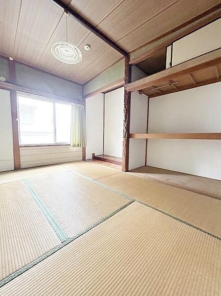 【一部AIによるモノ消し済み】大きな窓から明るい光が差し込む和室です。収納力のある押し入れが備わっておりすっきりとした空間が広がっています。畳敷きで落ち着いた雰囲気を演出しています。