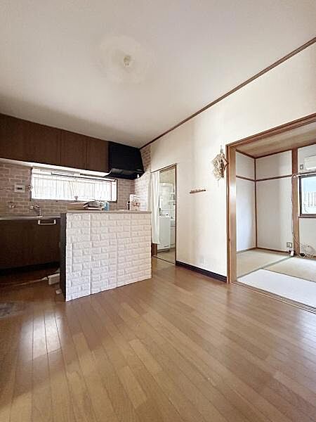 木目調の床が部屋全体に温かみを与えています。隣室とのつながりがあり開放感があります。リビング空間をすっきりと演出しています。