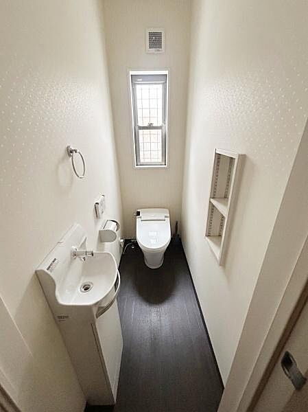 【一部AIモノ消し済み・実際の室内状況優先】シンプルで清潔感のあるトイレです。窓付きで自然光も入りやすい設計になっています。手洗いスペースも備えられており使い勝手に配慮されています。