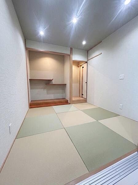 【一部AIモノ消し済み・実際の室内状況優先】和室ならではの落ち着いた雰囲気が感じられます。天井のダウンライトが空間を明るく演出しています。シンプルな内装が畳の美しさを引き立てています。