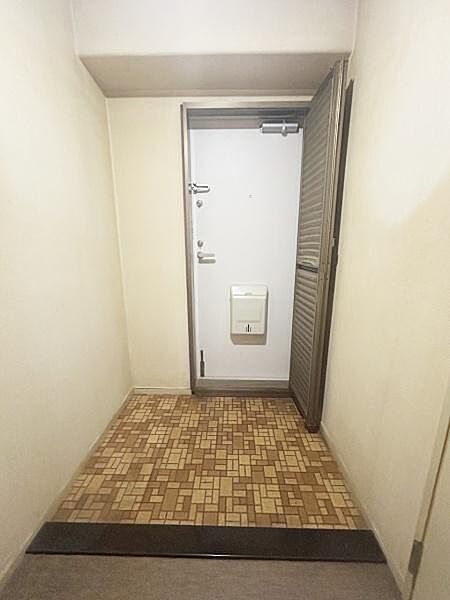 タイル床が特徴的な玄関は清潔感があります。シンプルで落ち着いた配色の室内です。