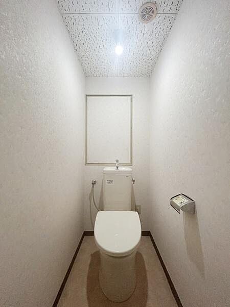 シンプルで機能的なトイレスペースです。壁や床が明るい色合いでまとめられており清潔感があります。