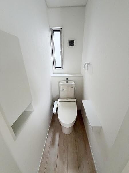 【一部AIモノ消し済み・実際の室内状況優先】白を基調としたシンプルなトイレ空間です。換気用の小窓付きで清潔感も感じられます。収納スペースも設けられており整理整頓しやすい仕様です。