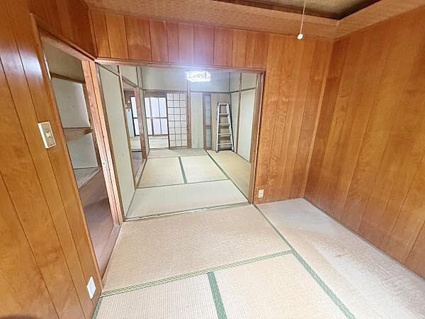 落ち着いた雰囲気の和室です。木目調の壁と畳がバランスよく調和しています。仕切り扉を開けることで空間を広く使えます。収納スペースも確保されています。和の趣を感じられます。