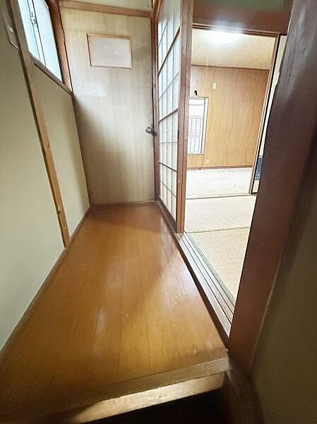 廊下は木目調の床で畳のお部屋へのアクセスがしやすくなっています。シンプルなデザインの壁面が空間をすっきりと見せています。障子扉が和の雰囲気を感じさせるポイントです。