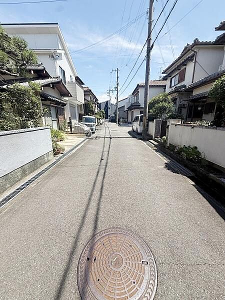 舗装された道路が続く静かな住宅街となっています。周囲の建物とのバランスが取れており落ち着いた雰囲気が感じられます。