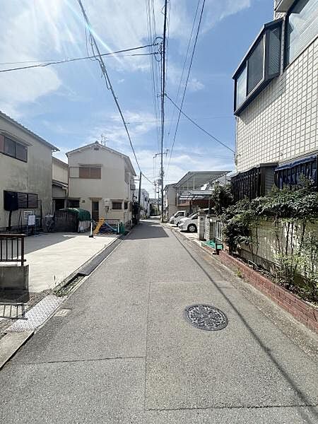 前面道路は車通りが少なく落ち着いた雰囲気です。道幅も確保されており歩行や車の出入りがしやすくなっています。周囲には住宅が並び整った街並みが広がっています。