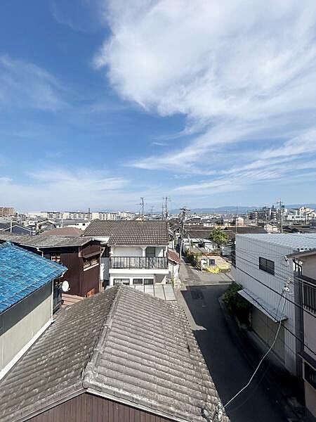 晴れた空が広がり遠くまで見渡せる現地からの眺望です。周辺には住宅が並び街並みがしっかりと確認できます。屋根越しに広がる景色が印象的です。日当たりも良く開放感を感じるロケーションです。