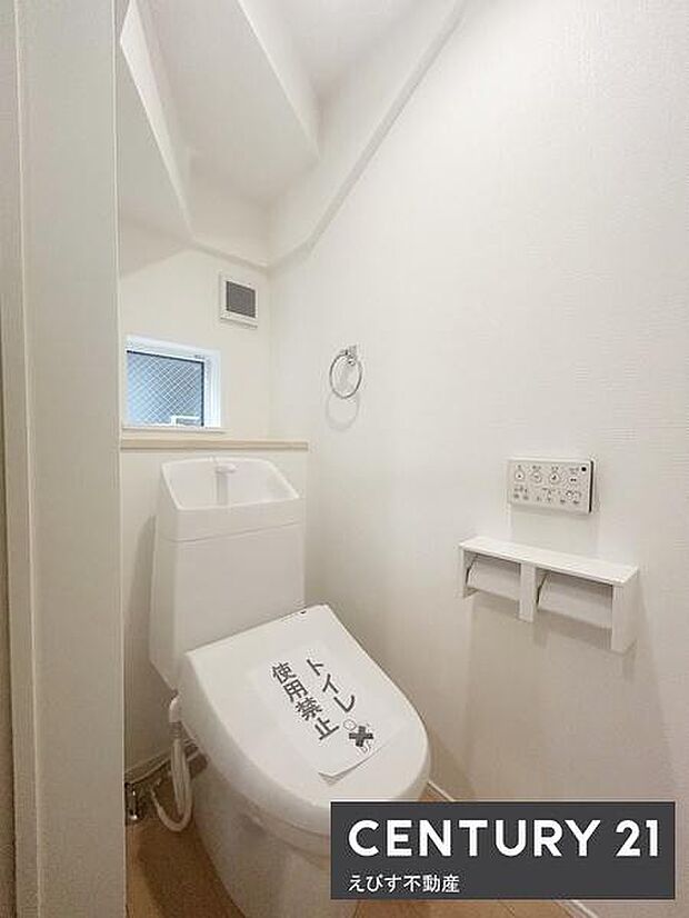 トイレは快適な温水洗浄便座付。すっきりと清潔感のあるトイレ空間です。換気に便利な窓が設置されています。床や壁はシンプルなデザインで手入れがしやすい構造です。明るい照明により快適な印象です。