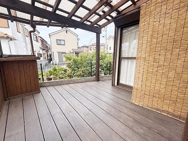【一部AIモノ消し済み・実際の室内状況優先】屋根付きのウッドデッキがあり雨の日でも利用できるスペースです。周囲には緑があり開放感のある空間となっています。