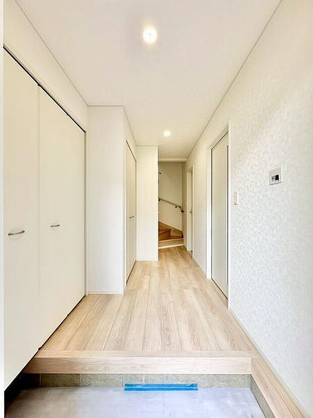白を基調とした明るい玄関は広々とした印象を与えます。スッキリとした収納扉が並んでおり玄関まわりの整理がしやすそうです。廊下奥には階段もあり室内への動線もスムーズです。