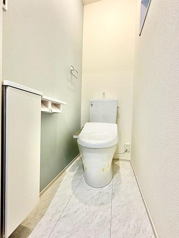 清潔感のあるシンプルなトイレ空間です。白を基調とした内装で明るく開放的な印象を与えます。収納スペースが備わっているので小物の整理にも便利です。手が届きやすい場所にペーパーホルダーが設置されています。