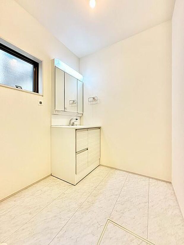 明るく清潔感のある洗面台・洗面所です。収納スペースが充実し使いやすさが感じられます。窓があり採光・換気にも配慮されています。シンプルなデザインで手入れも簡単です。