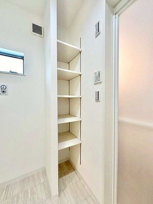 洗面所に便利な可動棚付きの収納スペースがあります。小物やタオルなどをすっきり整理できます。清潔感のある明るい内装です。通気口も設けられており快適な空間づくりに役立ちます。