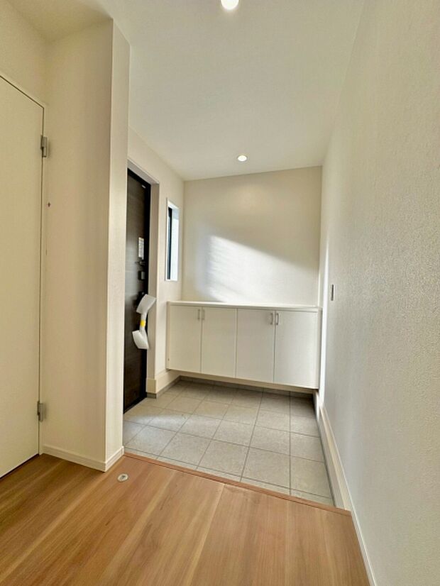 明るい玄関スペースは清潔感のある白を基調としたデザインです。収納も備わっておりスッキリとした印象です。床の素材の切り替えがメリハリを感じさせ使い勝手の良い空間です。